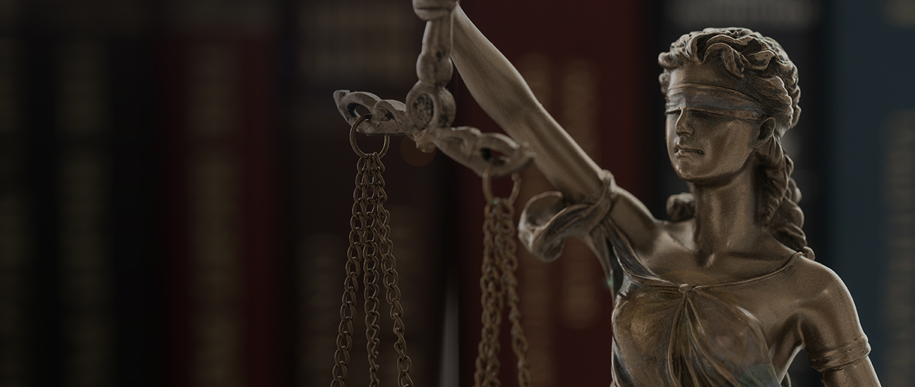 A statue of Lady Justice, blindfolded, holding a balanced scale in her right hand, symbolizing fairness and law.